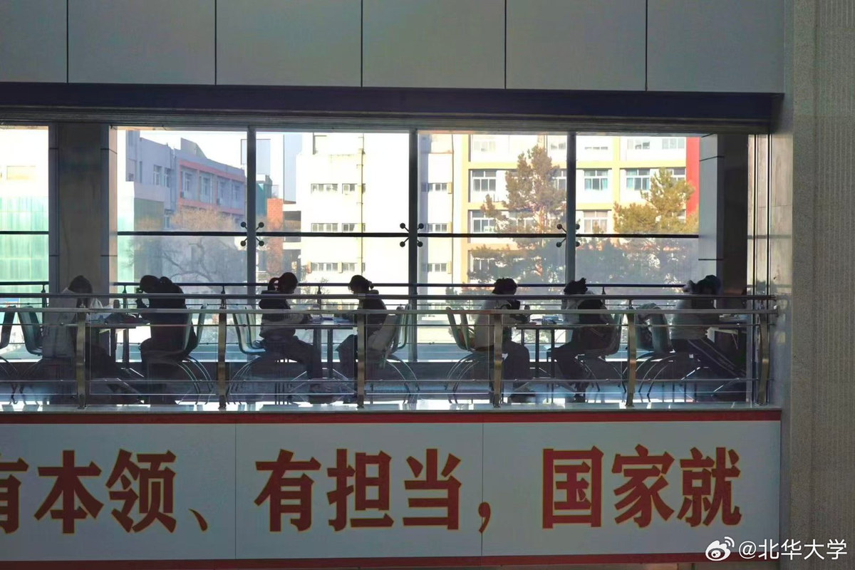 Beihua University library interior — study seating beside the glass windows